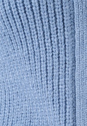 Acercamiento a una suave tela de punto azul claro con textura de ribete vertical y fibras de hilo visibles.