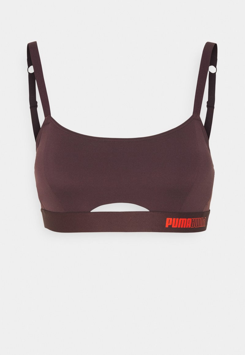Soutien-gorge de sport en tissu marron foncé avec bretelles ajustables. Présente un détail découpé et une bande élastique avec le logo "PUMA" rouge.