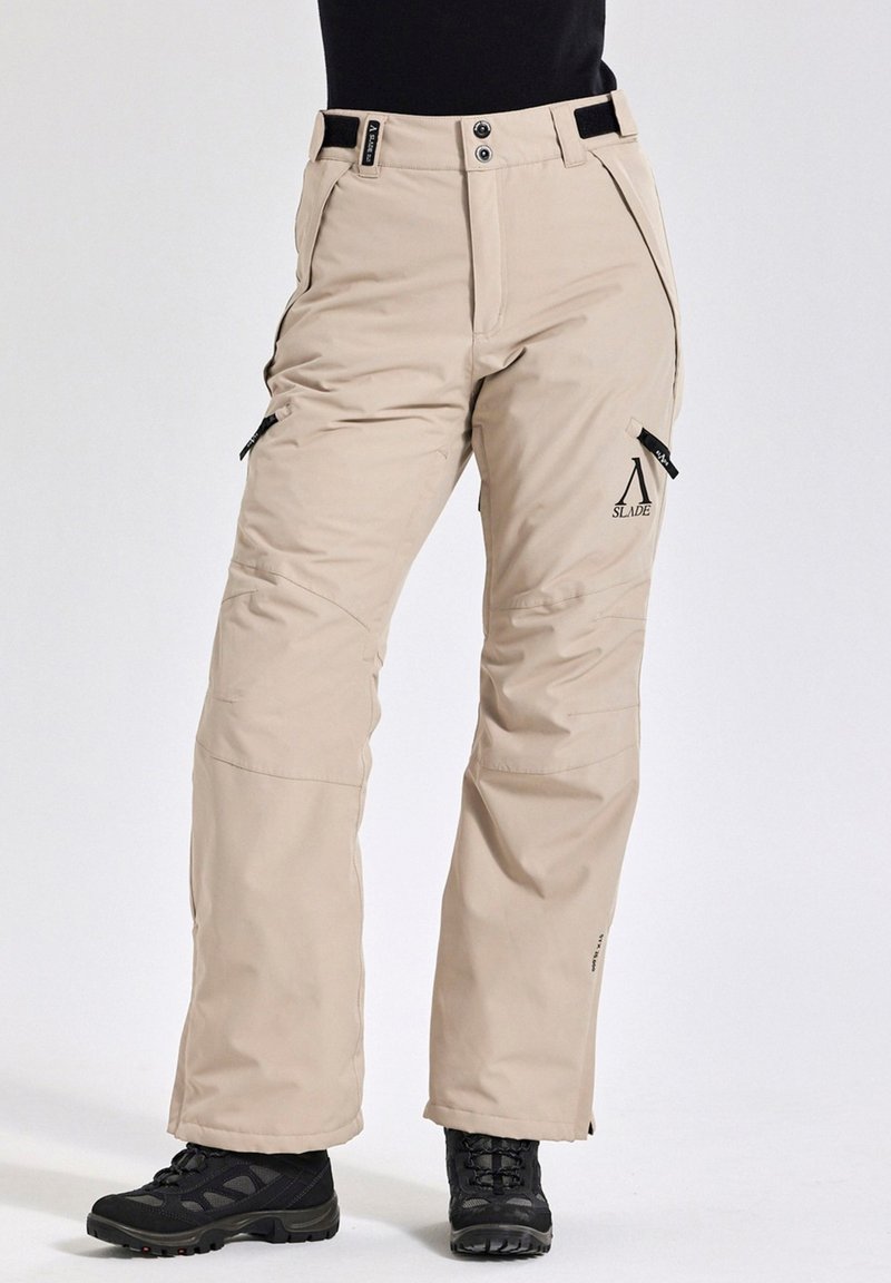 Beige geïsoleerde broek met verstelbare taille, zijritsen en logo-detail. Gemaakt van duurzaam materiaal, ontworpen voor buitenactiviteiten.