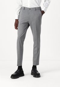 Szare spodnie w dopasowanym kroju, o gładkiej fakturze, z paskiem, guzikiem z przodu i bocznymi kieszeniami, w połączeniu z czarnymi mokasynami.