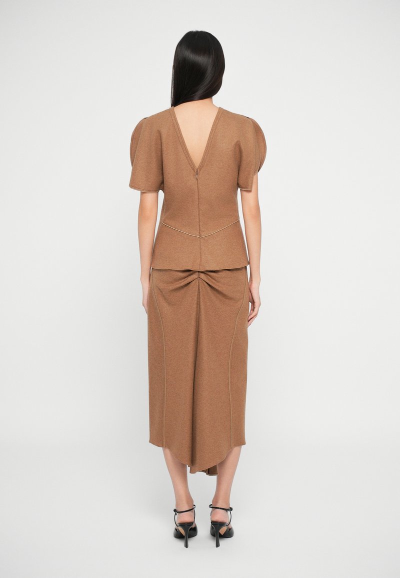Vestito a maglia marrone con texture, maniche a palloncino corte, scollatura profonda a V sul retro e dettagli arricciati in vita. L'orlo arrotondato si allunga leggermente sul retro.