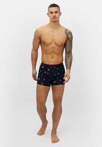 Marina kalsonger med ett festligt mönster av pepparkaksgubbar, godiskäppar och snöflingor. Mjukt material med ett kontrasterande rött midjeband.