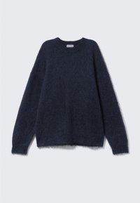 Pull en mohair bleu marine en tissu doux et texturé. Présente un col rond et des manches longues avec une coupe ample et décontractée.