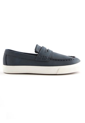 Mocassin slip-on bleu marine avec semelle en caoutchouc blanc et couture décorative, vue de côté sur fond blanc.