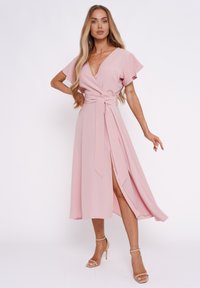Rosa Wickelkleid mit kurzen, flatternden Ärmeln, tiefem V-Ausschnitt und seitlichem Schlitz. Der Stoff hat eine glatte Textur und wird in der Taille mit einem passenden Gürtel gebunden.