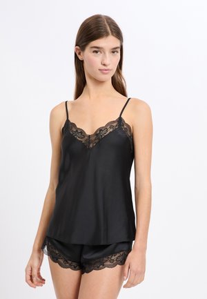 Camisole nera in raso con dettagli in pizzo lungo lo scollo, abbinata a pantaloncini coordinati con bordatura in pizzo all'orlo.