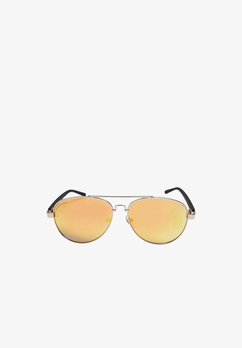 Metalliske aviator solbriller med store oransje linser, tynn sølvramme og svarte akcenttupper på templene. Rund form med minimal maskinvare.