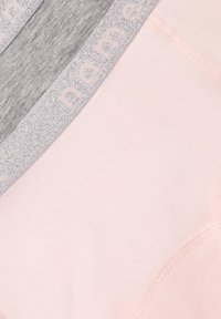 Tre pezzi di tessuto: grigio, rosa e una fascia in vita con accenti argentati e lettering in rilievo. Texture liscia con bordi cuciti.