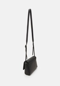 Borsa a tracolla nera con superficie testurizzata, forma rettangolare, tracolla regolabile e chiusura a patta. Design minimalista, senza hardware visibile.