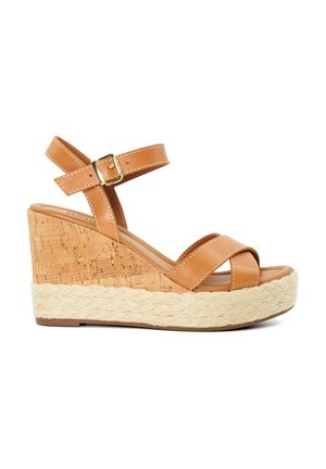 Tan leren wedge sandalen met twee gekruiste banden, kurk-textuur hak en gevlochten jute details. Gesp sluiting op de enkelband.