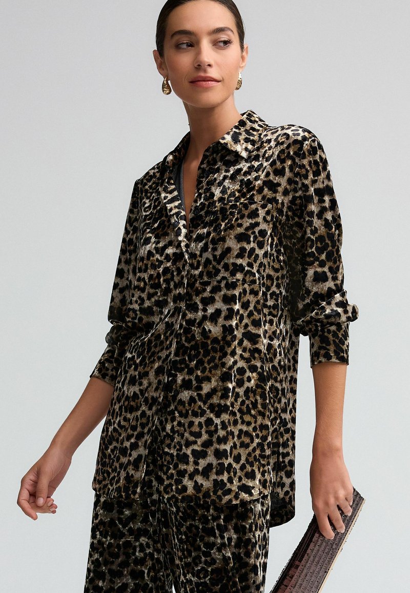 Leopardprint shirt in zachte velvet, met een knoopsluiting aan de voorkant, een borstzak en opgerolde mouwen. Donkere tinten met gouden accenten.
