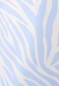 Tissu à motif zèbre bleu clair et blanc avec une texture lisse, présentant des rayures ondulées audacieuses qui créent un design distinctif.