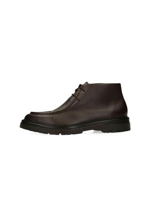 Bottine en cuir marron foncé avec semelle épaisse en caoutchouc noir et deux œillets pour lacets, présentée de profil sur fond blanc.