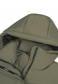 Giacca puffer verde oliva con cappuccio, dotata di chiusura con zip, bottoni a pressione e texture trapuntata. La fodera interna è nera.