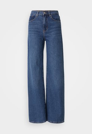 Jean taille haute, à jambes larges en denim bleu foncé. Comprend cinq poches, des passants de ceinture et une texture délavée avec des coutures contrastantes.
