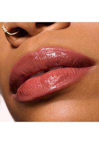 Glanzende roze lipkleur met een gladde textuur, die de natuurlijke lipcontouren benadrukt. Close-upweergave die glans en hydratatie benadrukt.