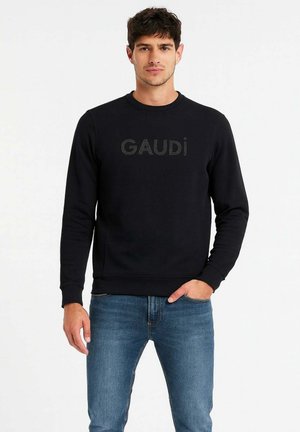Felpa nera a girocollo con logo "GAUDI" in una texture leggermente in rilievo, abbinata a jeans blu chiaro. Tessuto liscio, vestibilità rilassata.