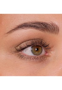 Primo piano di un occhio con ombretto bronzo scintillante, ciglia ben definite e un sopracciglio scuro ben curato, e una texture della pelle leggermente abbronzata.