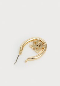 Guld hoopörhänge med en slank cirkulär design och en 3D 'XOXO'-detalj. Slät yta och glänsande textur; lättvikts metallkonstruktion.