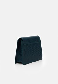 Prostokątna torba na ramię w kolorze morskim, wykonana z teksturowanego, wzorzystego materiału. Posiada zakładany klapę i usztywnioną podstawę zapewniającą stabilność.