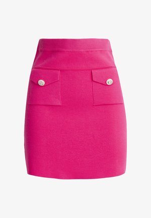 Aansluitende roze gebreide rok met een geribbelde tailleband, twee voorzakken met decoratieve knopen en een gestructureerde stof.