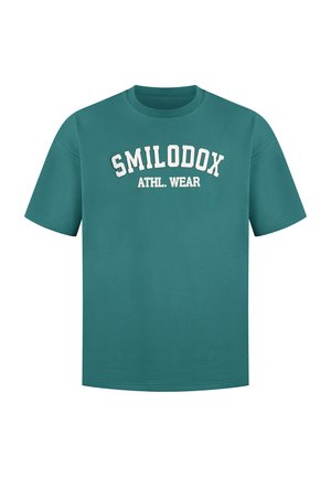 T-shirt in cotone blu verde con maniche corte e collo rotondo. Presenta la scritta bianca 'SMILODOX ATHL. WEAR' ad arco sul davanti.