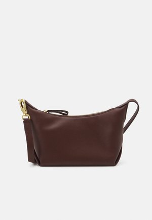 Bolso de mano de cuero marrón oscuro con cremallera dorada y correa desmontable sobre un fondo claro y liso.