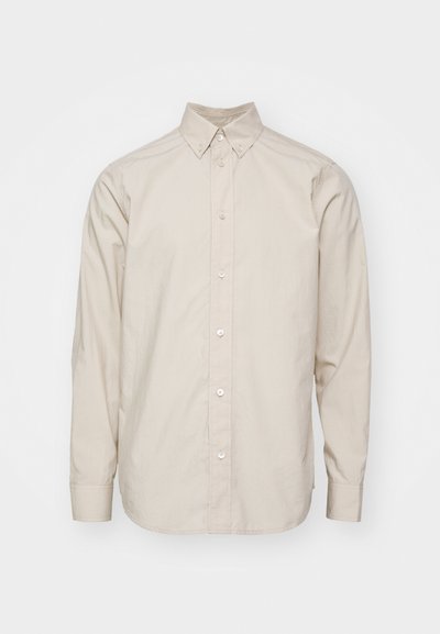 Beige langærmet skjorte med knaplukning og krave; stoffet ser glat ud; har klassisk knaplukning og manchetter.