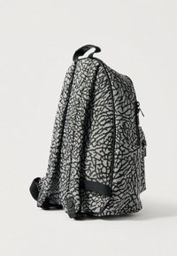 Γκρι σακίδιο με υφή σε μαύρο σχέδιο. Διαθέτει φερμουάρ, πλαϊνή τσέπη και επάνω χερούλι. Κατασκευασμένο από ανθεκτικό ύφασμα, ορθογώνιο σχήμα.