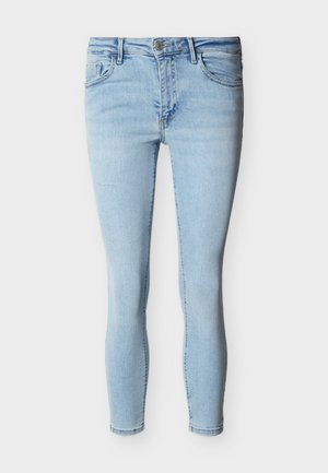 Jean skinny bleu clair avec bouton frontal, fermeture éclair et design à cinq poches sur fond blanc.