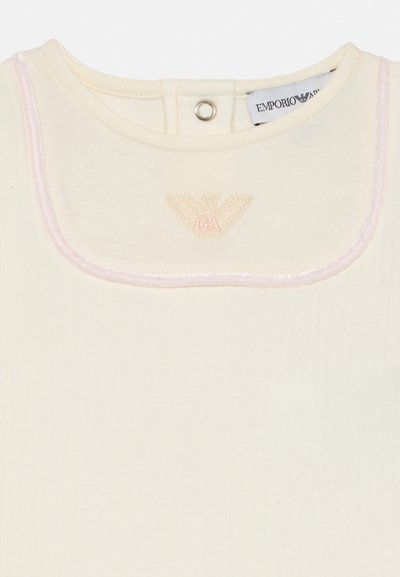 Kreemikas beebibodi kahvatu roosa äärisega, elastse kinnitusega kaelusel ning tikitud Emporio Armani logo rinnal.