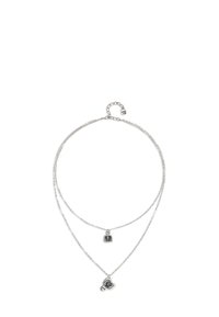 Collier à plusieurs couches en argent avec deux chaînes. Une chaîne affiche un pendentif carré, tandis que l'autre présente un pendentif rond. Design simple, texture lisse.