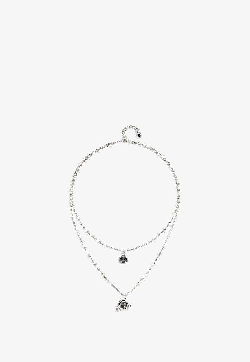 Collier à plusieurs couches en argent avec deux chaînes. Une chaîne affiche un pendentif carré, tandis que l'autre présente un pendentif rond. Design simple, texture lisse.
