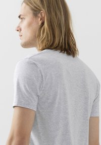 T-shirt grigio a maniche corte realizzato in morbido cotone. Texture liscia con scollatura a girocollo. Presenta una vestibilità comoda e dettagli di cucitura minimali.