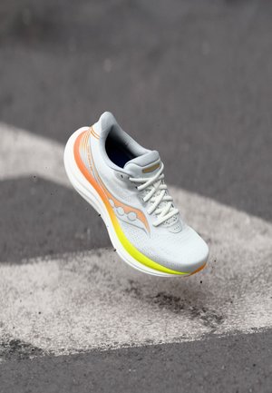 Kerged jooksukingad, millel on hall võrkkangas orelanged ja kollaste aktsentidega, pehmendatud tald ja tekstureeritud varbavõlv.