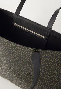 Zwarte tas van textuur met groen bladpatroon, voorzien van twee stevige handvaten, een ritsvak aan de binnenkant en subtiele geperste branding.