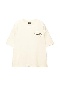 Kremowy, oversize'owy t-shirt z miękkiego materiału, z nadrukowanym kursywą logo na lewym obszarze klatki piersiowej oraz krótkimi rękawami.