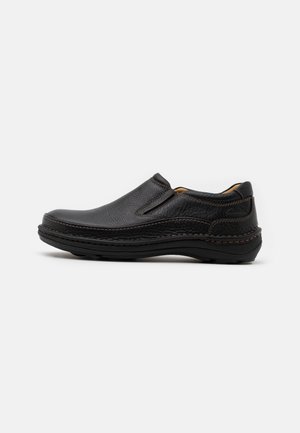 Black slip-on shoe made of textured leather, featuring subtle stitching accents and a cushioned sole for comfort. Smooth finish throughout.