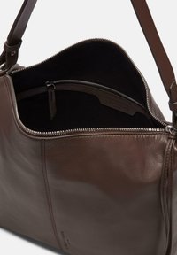 Brązowa torba skórzana o gładkiej fakturze, z zamkiem błyskawicznym i wewnętrzną kieszenią. Posiada odpinany pasek oraz subtelne detale przeszycia.