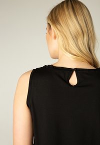 Black sleeveless top featuring a small keyhole detail at the back neckline, made of soft fabric with a smooth texture.