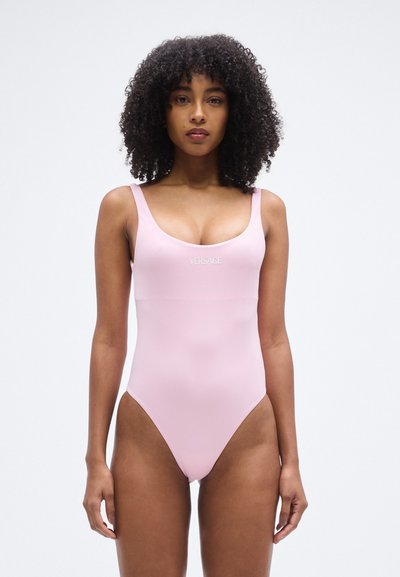 Maillot de bain une pièce rose à texture lisse, doté de larges bretelles et d'un décolleté arrondi. Logo "VERSACE" affiché sur le devant.