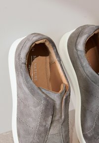 Gray suede slip-on shoes with white rubber soles. Features a textured surface, tonal stitching, and a soft leather lining. Size 41.