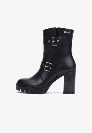 Bottines en cuir noir à talon épais, avec deux sangles réglables et boucles dorées, et une semelle en caoutchouc texturé.