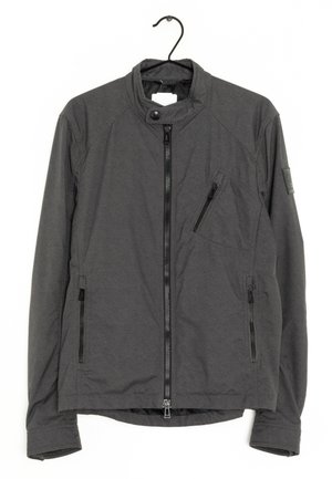 Dunkelgraue Zip-up-Jacke mit Stehkragen, drei Reißverschlusstaschen und Druckknopfdetail am Kragen, hängt an einem schwarzen Kleiderbügel.