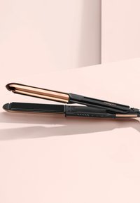 Fer à lisser noir avec des accents dorés roses. Il présente un design épuré, des bords arrondis et des boutons de contrôle sur le manche.