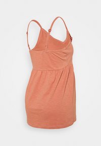 Tank top v broskvové barvě s tenkými nastavitelnými ramínky, zřasenou texturou v pase a měkkým, lehkým materiálem.