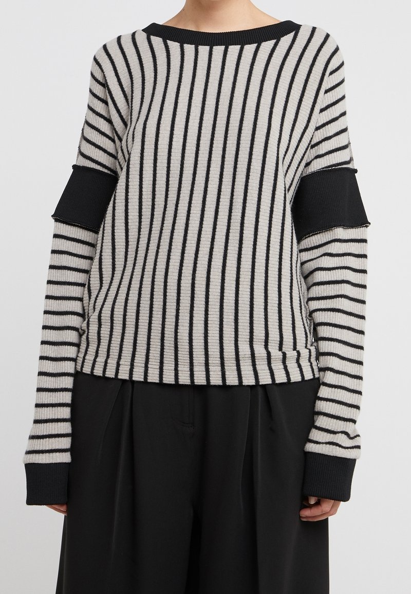 Grå och svart randig tröja med en avslappnad passform, med ribbade ärmslut och en platt halsringning. Mjuk textur, avslappnad design.