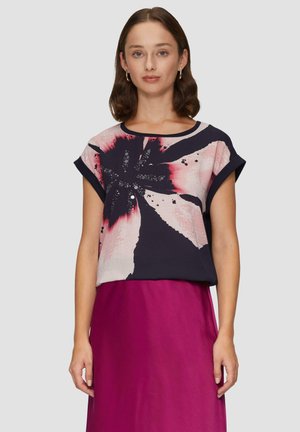 Korte mouw blouse in donker marineblauw met een roze en zwarte bloemenpatroon. Glad materiaal, ronde halslijn, relaxte pasvorm, gecombineerd met een fuchsia rok.