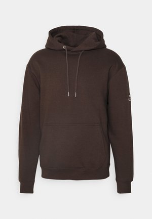 Brun hættejakke lavet af blødt stof, med en frontlomme, justerbare snore og ribbede manchetter. Minimalistisk design uden mønstre.