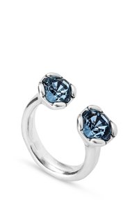 Anillo de tono plateado que presenta dos cristales azules octagonales en engastes de garra, diseño de banda abierta con acabado pulido.